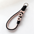 Handwoven black and pink braided cotton phone wristlet strap with flower accents and ring clasp - Rove Cord
